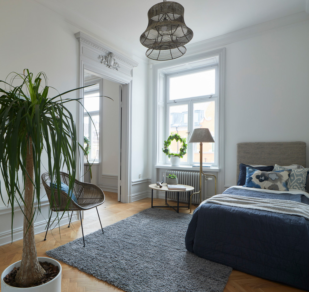 Idee per una camera da letto nordica con pareti bianche, parquet chiaro e pavimento beige
