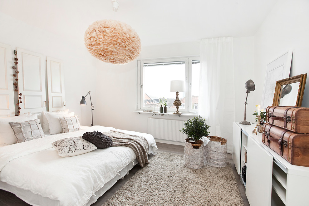 Стильный дизайн: большая хозяйская спальня в скандинавском стиле с белыми стенами и темным паркетным полом без камина - последний тренд
