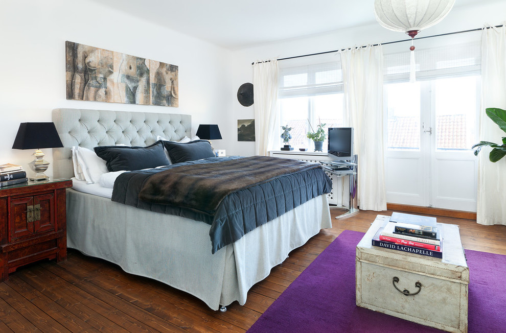 Ejemplo de dormitorio principal y televisión clásico de tamaño medio sin chimenea con paredes blancas y suelo de madera en tonos medios
