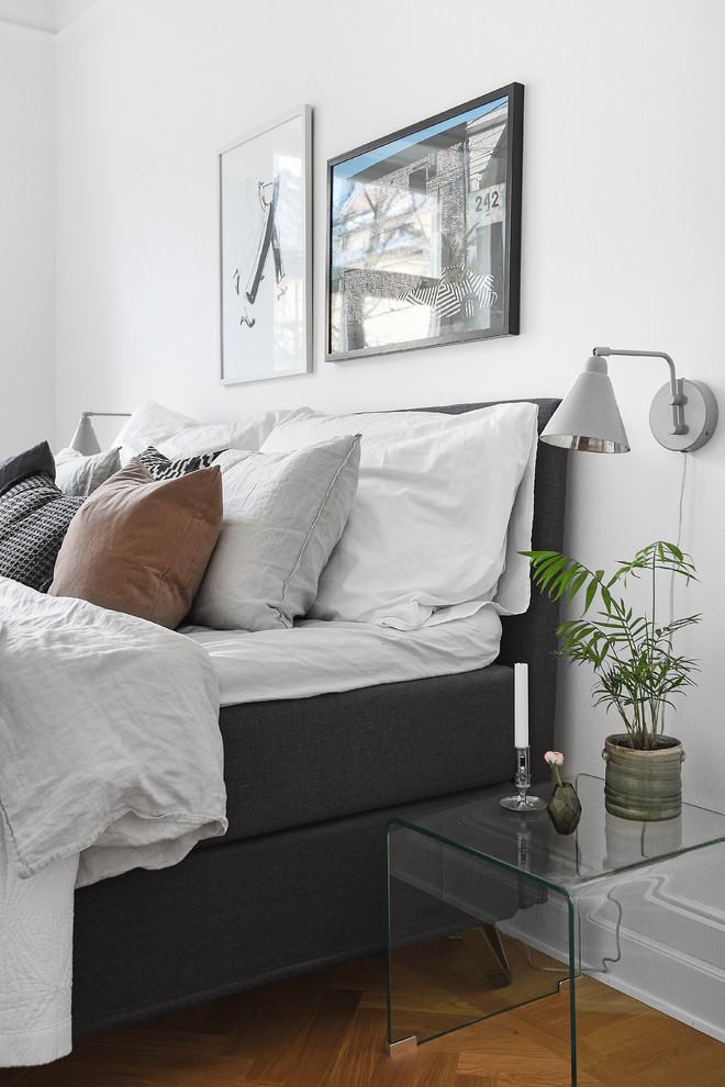 Ejemplo de dormitorio principal nórdico de tamaño medio con paredes blancas y suelo de madera clara