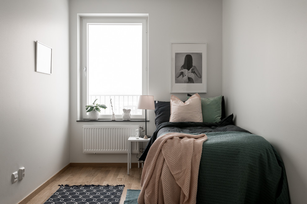 Exempel på ett skandinaviskt gästrum, med vita väggar, ljust trägolv och beiget golv