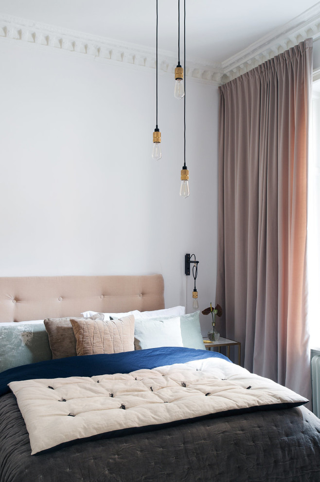На фото: хозяйская спальня среднего размера в скандинавском стиле с белыми стенами с