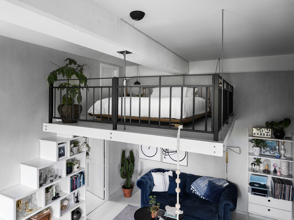 Nordisches Schlafzimmer im Loft-Style mit grauer Wandfarbe, gebeiztem Holzboden und weißem Boden in Stockholm
