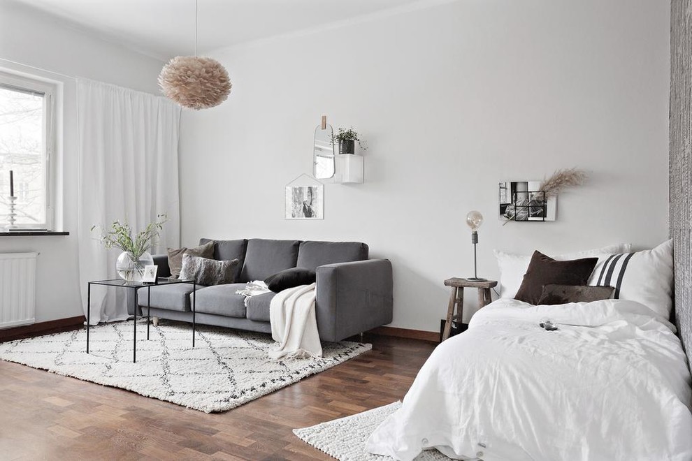 Ispirazione per una camera da letto scandinava di medie dimensioni con pareti bianche, parquet scuro e pavimento marrone