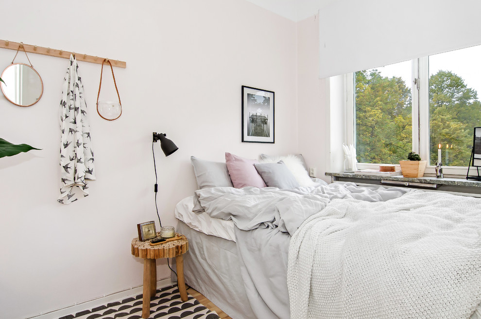Cette image montre une chambre d'amis nordique de taille moyenne avec un mur rose.