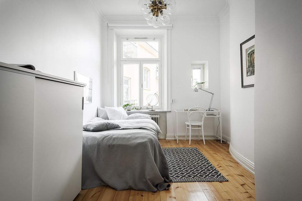 Идея дизайна: спальня в скандинавском стиле с белыми стенами, паркетным полом среднего тона и коричневым полом