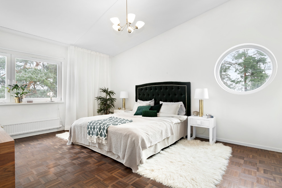 Immagine di una grande camera matrimoniale classica con pareti bianche, pavimento in legno massello medio e pavimento marrone