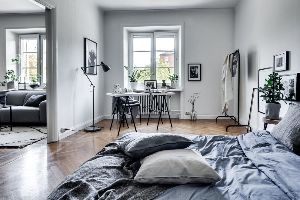 ストックホルムにある広い北欧スタイルのおしゃれな主寝室 (白い壁、暖炉なし、淡色無垢フローリング) のインテリア