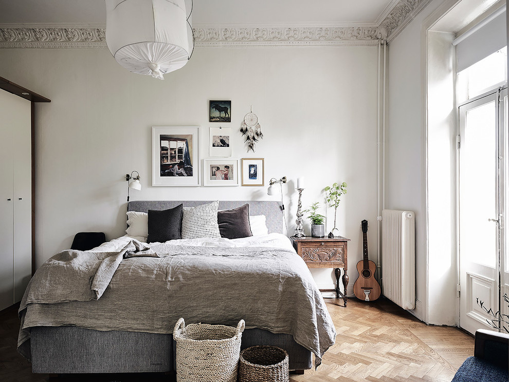 Idées déco pour une chambre parentale grise et blanche scandinave de taille moyenne avec parquet clair et un mur blanc.