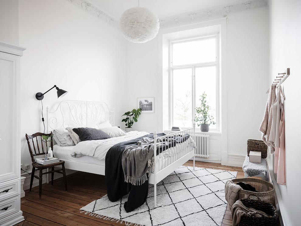 Idées déco pour une chambre scandinave de taille moyenne avec un mur blanc, un sol marron et un sol en bois brun.