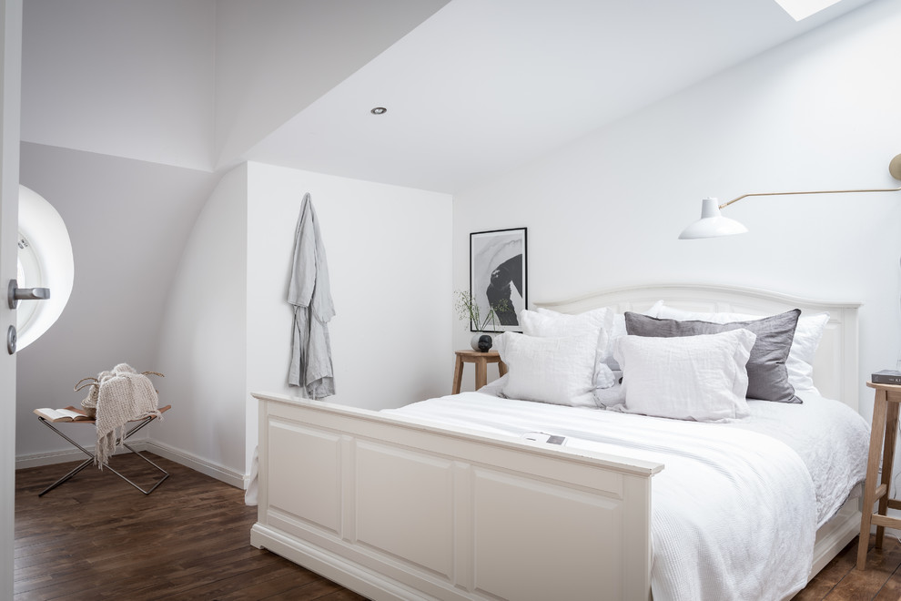 Skandinavisches Hauptschlafzimmer ohne Kamin mit weißer Wandfarbe, dunklem Holzboden und braunem Boden in Göteborg