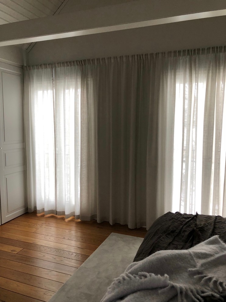 Foto di una camera da letto minimal di medie dimensioni con pareti grigie e pavimento in legno massello medio