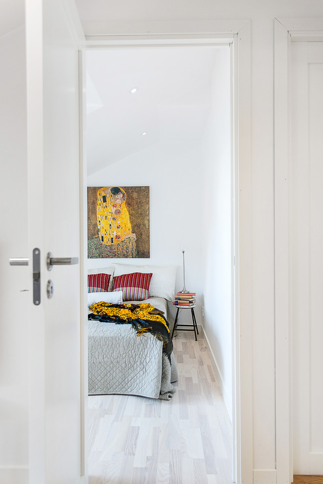 Inspiration för mellanstora minimalistiska huvudsovrum, med vita väggar och ljust trägolv
