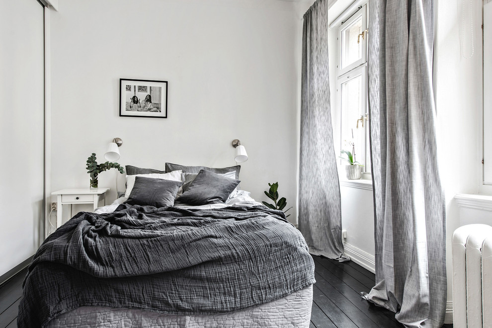 Inspiration för ett litet skandinaviskt sovrum, med vita väggar, målat trägolv och svart golv