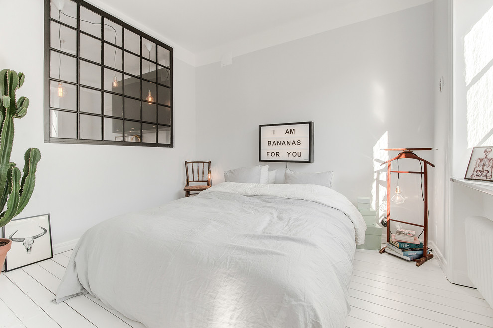 Ejemplo de dormitorio principal escandinavo de tamaño medio con paredes grises, suelo de madera pintada y suelo blanco