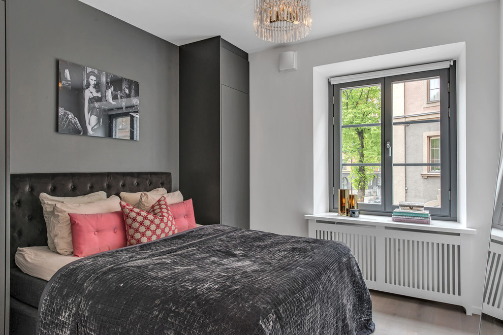 Mittelgroßes Modernes Hauptschlafzimmer ohne Kamin mit grauer Wandfarbe und hellem Holzboden in Stockholm
