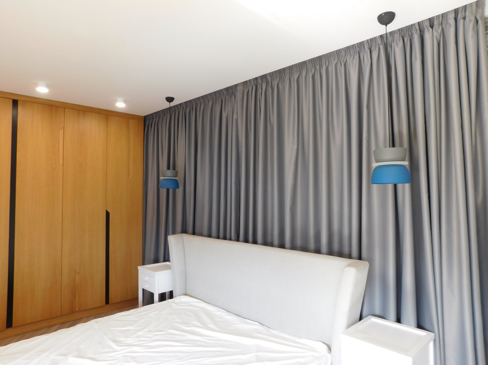 На фото: большая хозяйская спальня в современном стиле с белыми стенами, полом из ламината и серым полом без камина