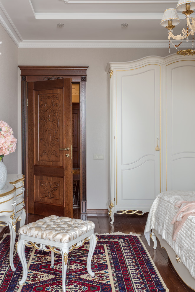 Foto de dormitorio principal tradicional de tamaño medio sin chimenea con paredes grises, suelo de madera en tonos medios y suelo marrón