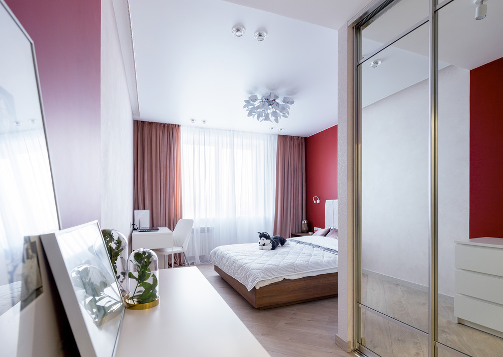 Foto de dormitorio principal actual de tamaño medio con paredes rojas, suelo laminado y suelo beige