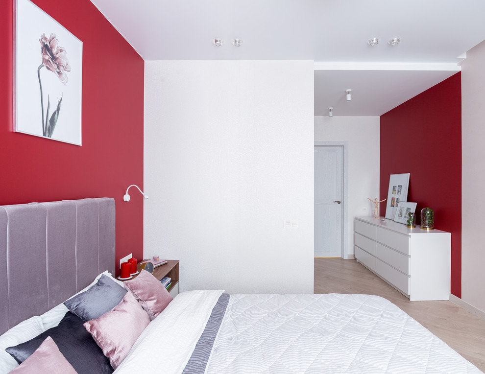 Immagine di una camera matrimoniale contemporanea di medie dimensioni con pareti rosse, pavimento in laminato e pavimento beige