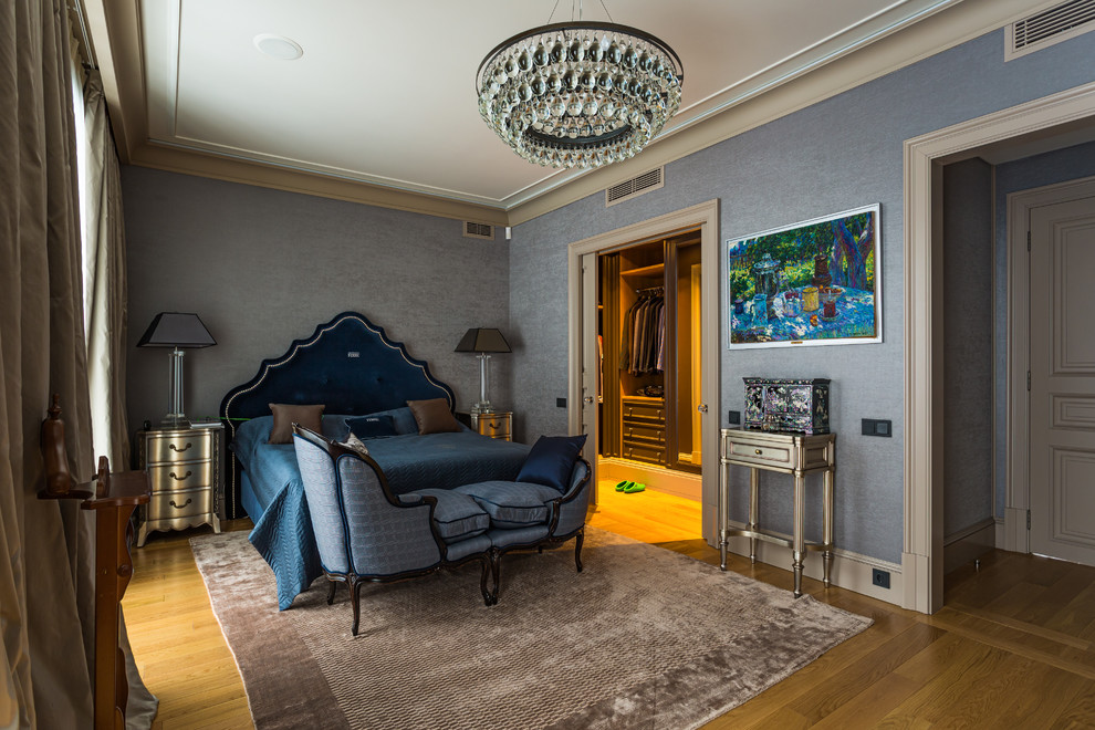 Imagen de dormitorio principal clásico con paredes grises, suelo de madera en tonos medios y suelo marrón