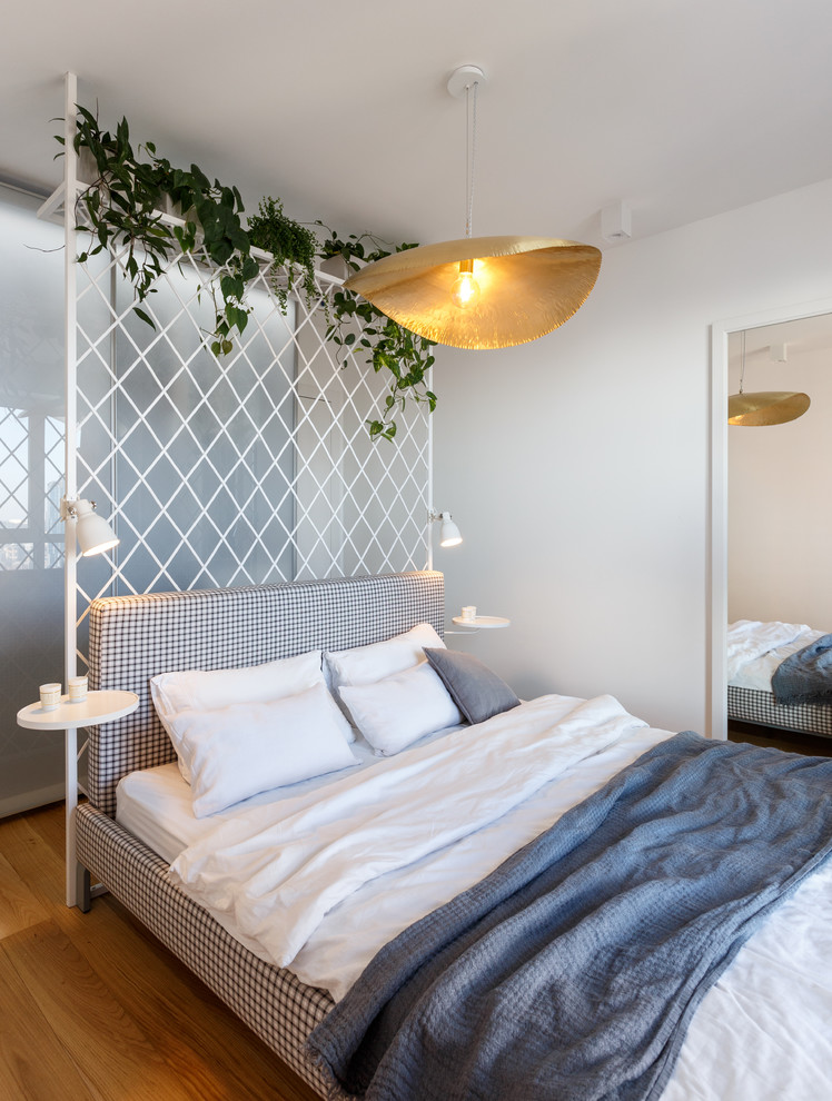 Esempio di una camera da letto minimal con pareti bianche, pavimento in legno massello medio e pavimento marrone
