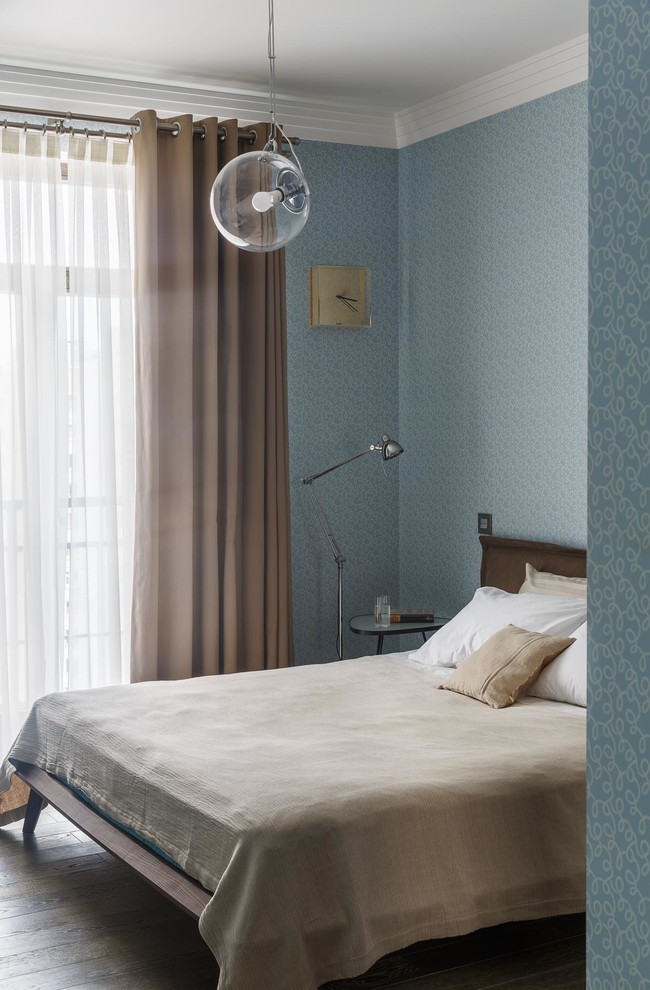 Foto på ett funkis sovrum, med blå väggar och mörkt trägolv