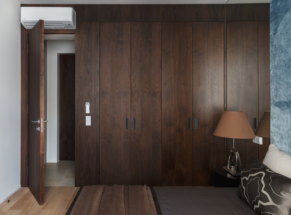 Idées déco pour une chambre parentale contemporaine de taille moyenne avec un mur blanc et un sol en bois brun.