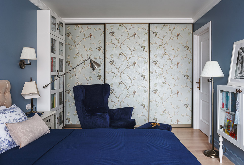 Imagen de dormitorio principal clásico con paredes azules y suelo de madera clara
