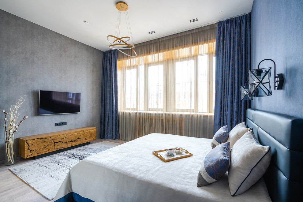 Свежая идея для дизайна: хозяйская спальня среднего размера в современном стиле с синими стенами, полом из ламината, серым полом и синими шторами без камина - отличное фото интерьера