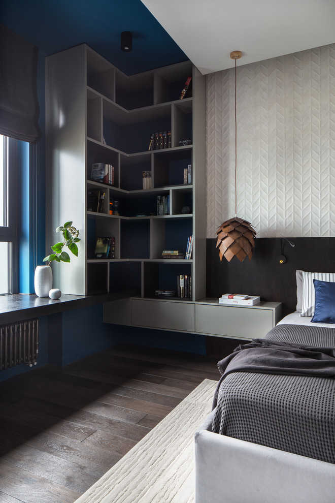 Cette image montre une chambre parentale design de taille moyenne avec un mur bleu et parquet foncé.