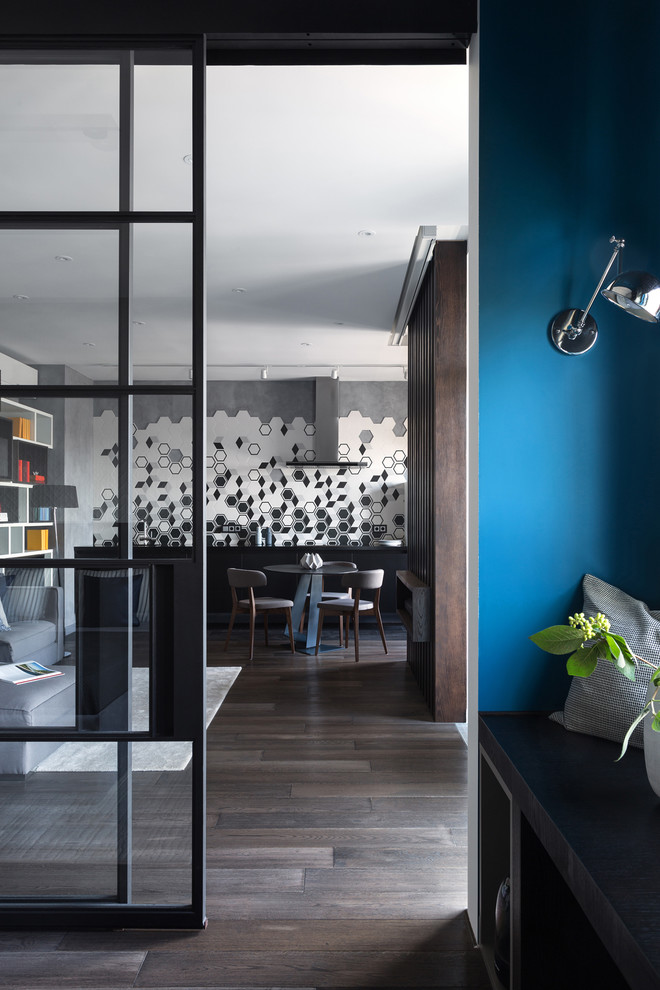 Immagine di una camera matrimoniale contemporanea di medie dimensioni con pareti blu e parquet scuro