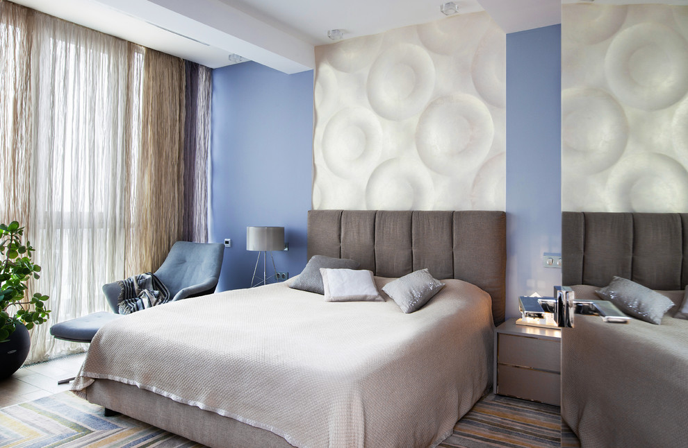 Modelo de dormitorio principal contemporáneo de tamaño medio con paredes azules, moqueta y suelo multicolor