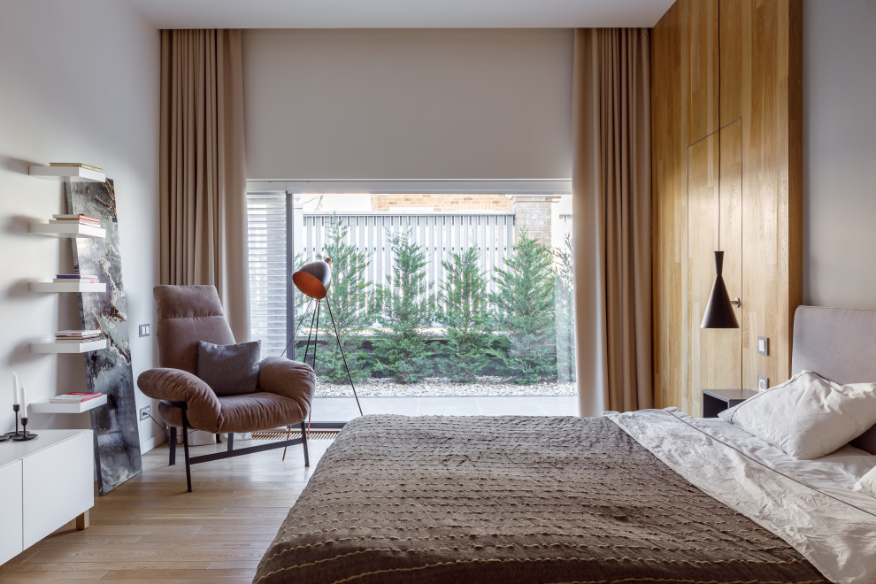 Стильный дизайн: большая хозяйская спальня в современном стиле с бежевыми стенами, светлым паркетным полом и бежевым полом - последний тренд