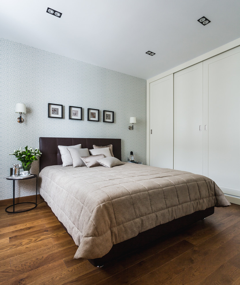 Imagen de dormitorio principal actual de tamaño medio con suelo de madera en tonos medios