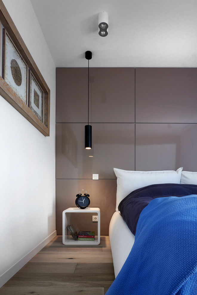 Идея дизайна: хозяйская спальня в современном стиле с белыми стенами и паркетным полом среднего тона без камина