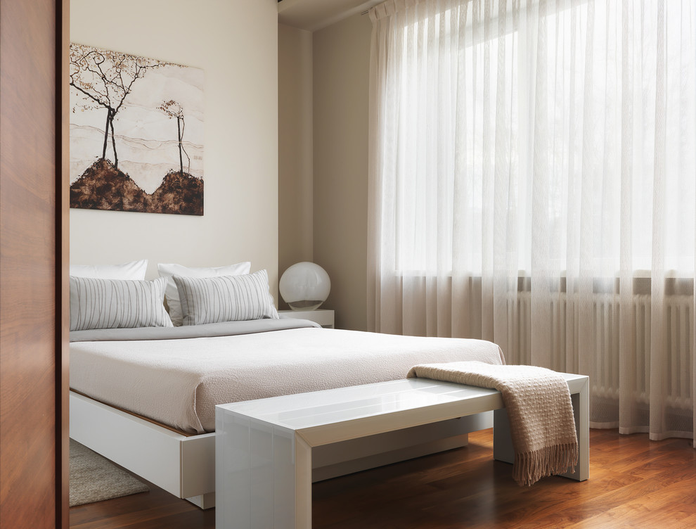 На фото: хозяйская спальня в современном стиле с бежевыми стенами, паркетным полом среднего тона и коричневым полом