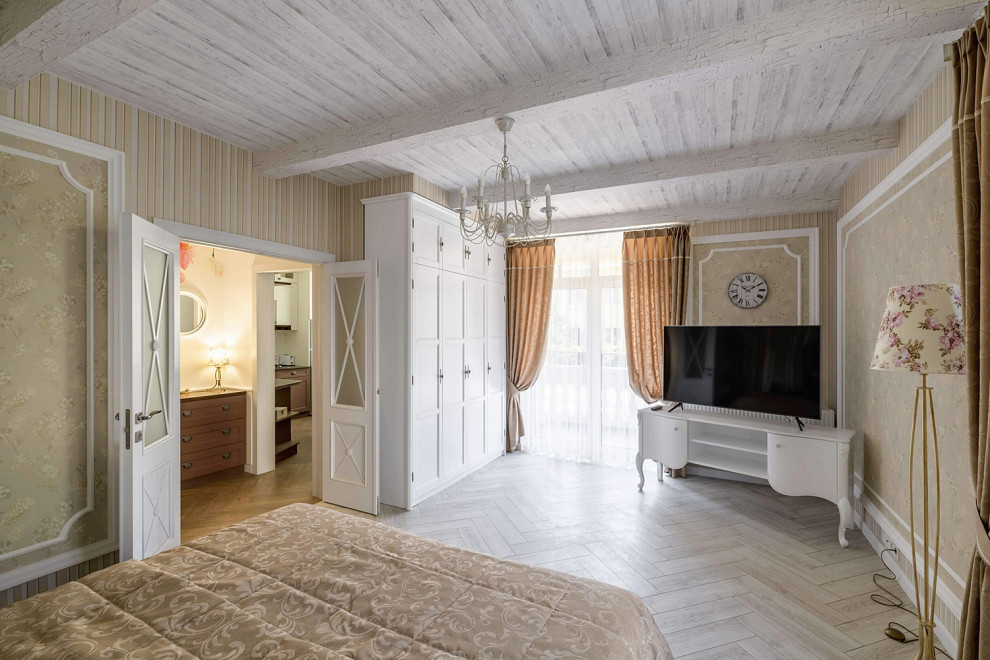 Diseño de dormitorio principal campestre de tamaño medio con paredes beige, suelo laminado, suelo blanco, vigas vistas y papel pintado