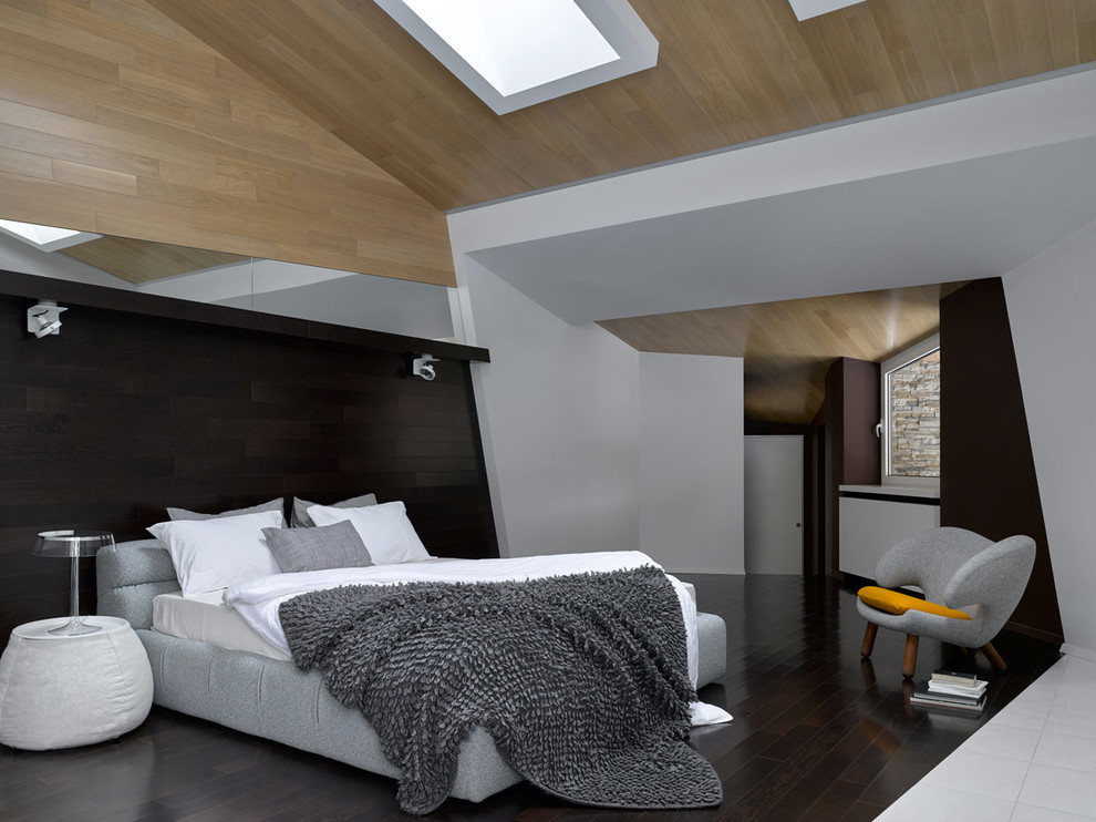 На фото: хозяйская спальня в современном стиле с белыми стенами, темным паркетным полом и коричневым полом с