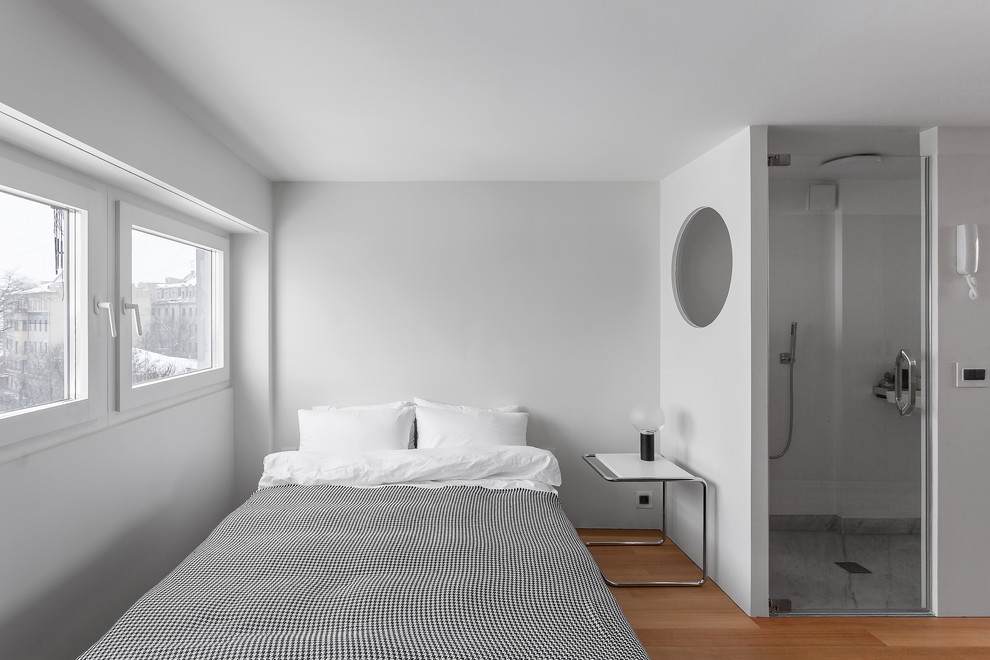 Imagen de dormitorio principal actual pequeño con paredes blancas y suelo de madera en tonos medios