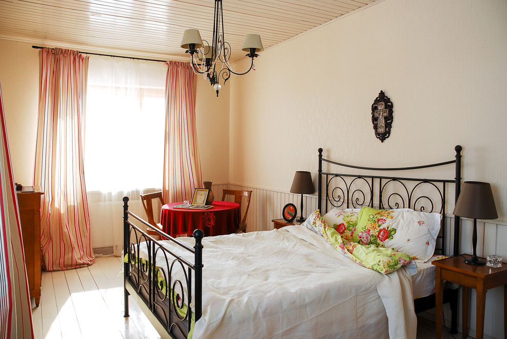Immagine di una camera degli ospiti tradizionale con pavimento in legno verniciato e pareti bianche
