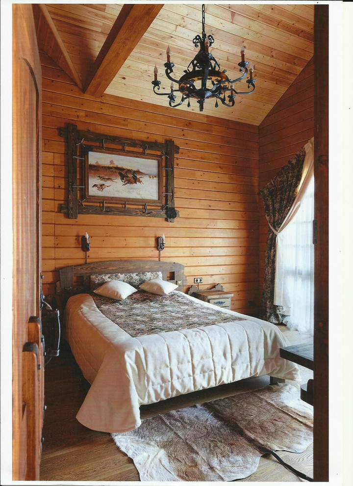 Пример оригинального дизайна: хозяйская спальня среднего размера в стиле рустика с коричневыми стенами и деревянным полом без камина