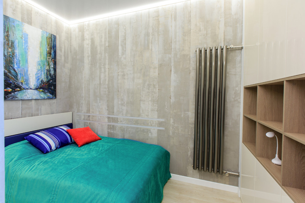 Foto di una camera da letto industriale con pareti grigie, parquet chiaro e pavimento beige