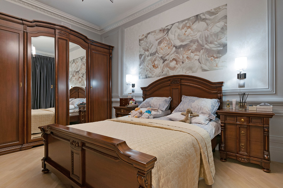 Inredning av ett klassiskt sovrum, med grå väggar, ljust trägolv och beiget golv