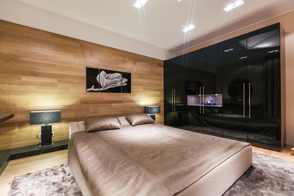 На фото: большая хозяйская спальня в современном стиле с бежевыми стенами, светлым паркетным полом и коричневым полом с