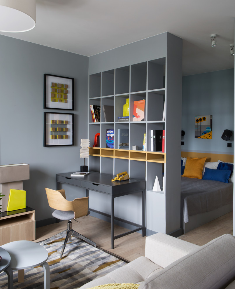 Inspiration pour une petite chambre parentale design avec un mur gris et parquet clair.
