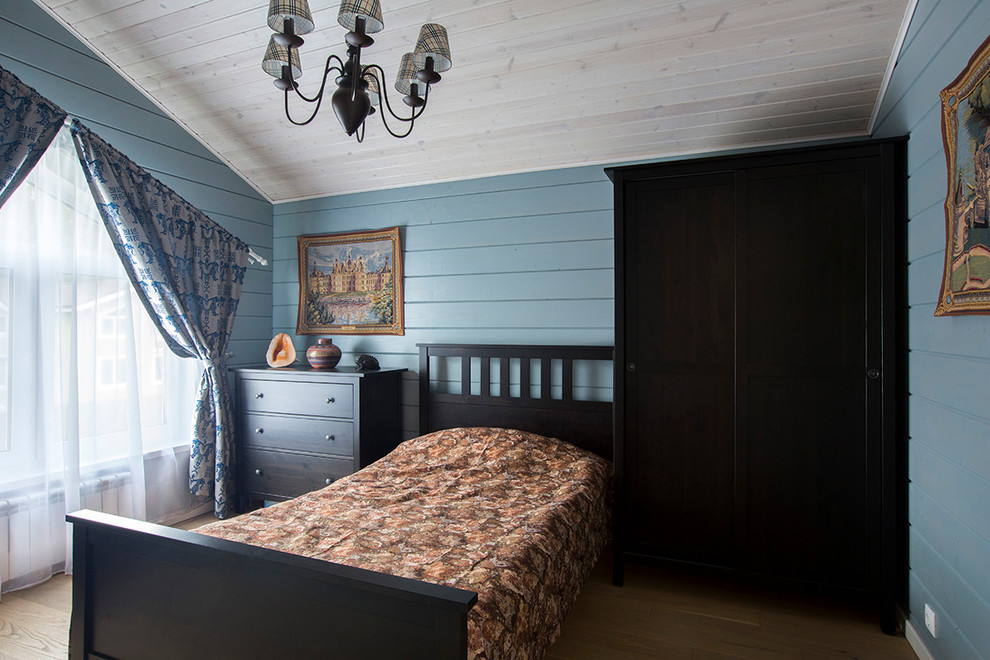 Esempio di una camera da letto country con pareti blu e parquet chiaro