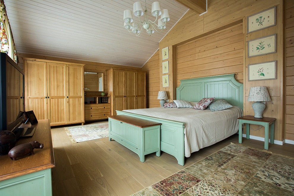 Modelo de dormitorio principal de estilo de casa de campo con paredes marrones y suelo de madera clara