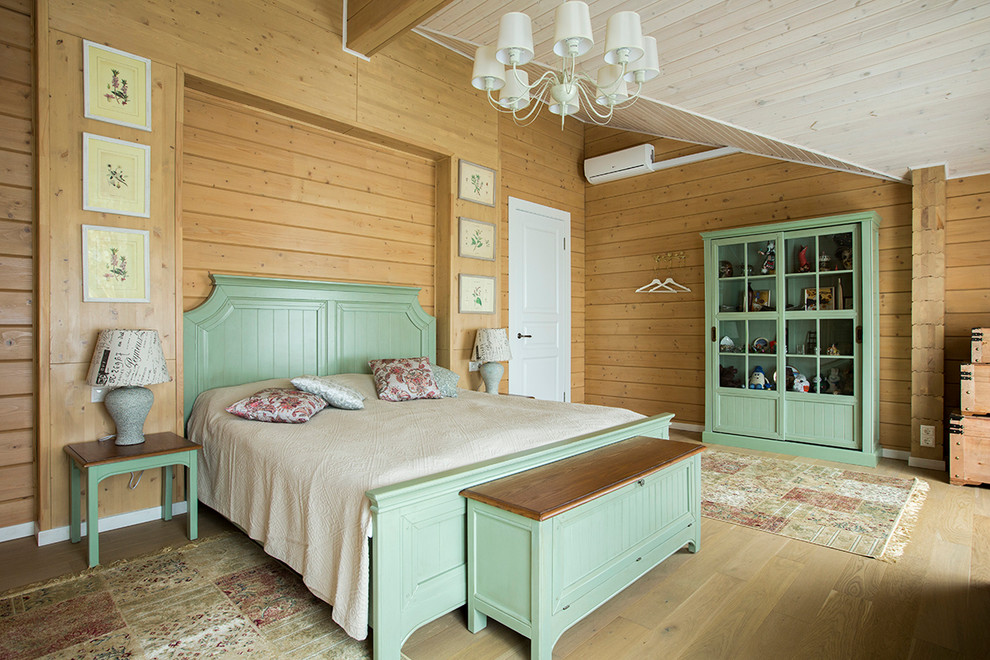 Modelo de dormitorio principal de estilo de casa de campo con paredes marrones y suelo de madera clara