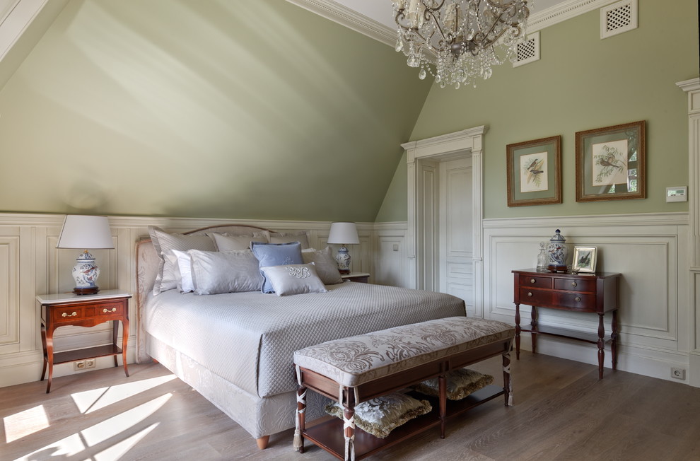 Immagine di una camera da letto tradizionale con pareti verdi, pavimento in legno massello medio e pavimento marrone